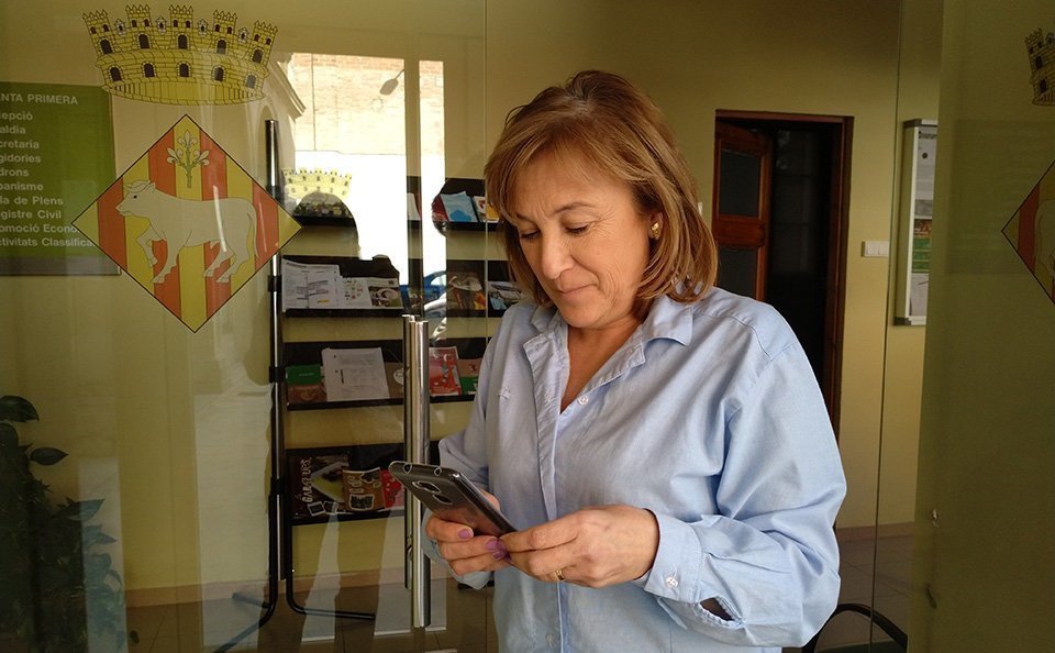 La regidora Núria Palau observant la nova aplicació mòbil.