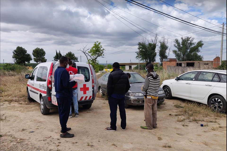 Voluntaris de la Creu Roja atenent usuaris d'un assentament de temporers - Foto: Creu Roja