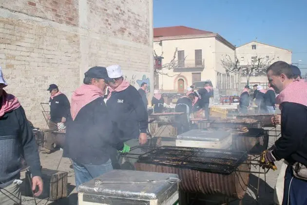 Els veïns del Poal preparen la carn per al dinar popular.