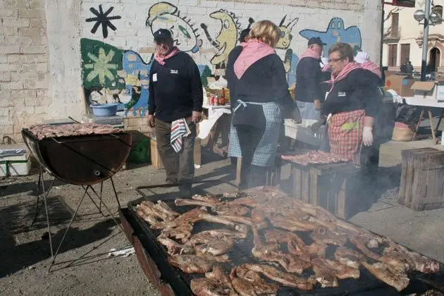 Els veïns del Poal preparen la carn per al dinar popular.