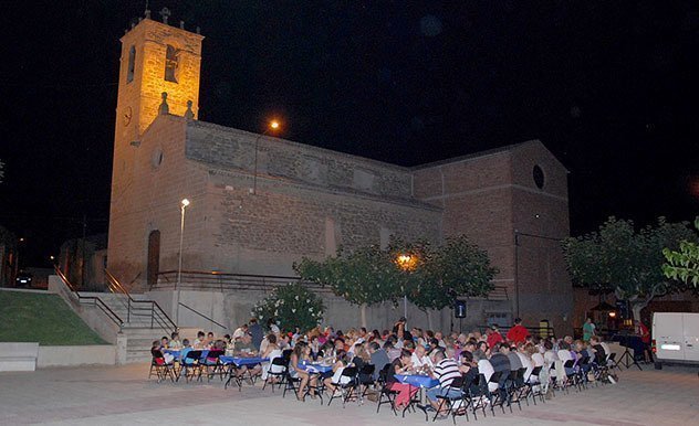El sopar es va celebrar a la plaça Major, amb la imatge de l&#39;església al fons.