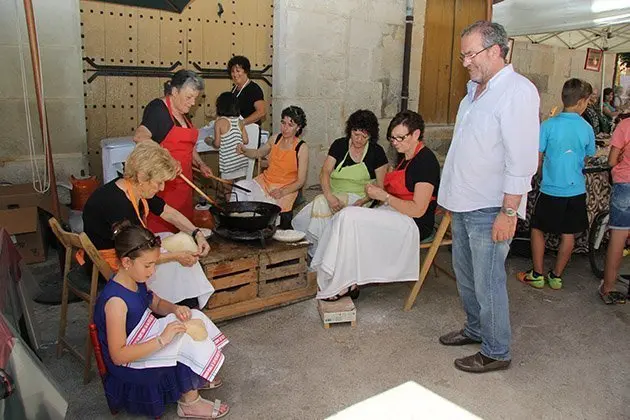 L'alcalde Joan Reñé observa l'elaboració de les orelletes.