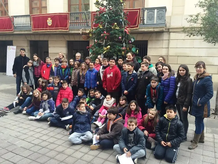 Els alumnes del Col·legi Mare de Déu de Montserrat després de penjar els seus desitjos a l'Arbre de Nadal de les Borges