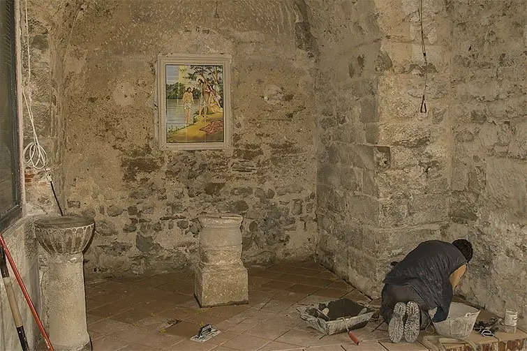 Obres en l'esglèsia de santa Maria de Barbens, amb el peu de la pila baptismal