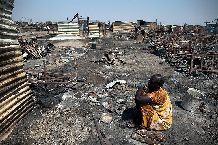 26 february 2016. Malakal : Akki Adduok, a displaced woman residing in the Protection of Civilians (PoC) site in Malakal, South Sudan, sits in the spot where there used to be her shelter.Fighting between elements of the Shilluk and Dinka communities erupted in the Malakal PoC on February 17 and continued on February 18. UN reports confirm that armed men in Sudan People's Liberation Army (SPLA) uniforms entered the UN camp and fired on civilians, looting and burning tents. At least 18 people were killed and more than 90 wounded.After the clashes, Dinka families (approximately 4,000 people) fled outside the PoC and sought refugee into Malakal town, while about 26,000 Nuer and Shilluk IDPs, mostly women and children, sought refugee in the former PoC.Photo by Albert Gonzalez Farran / AFP