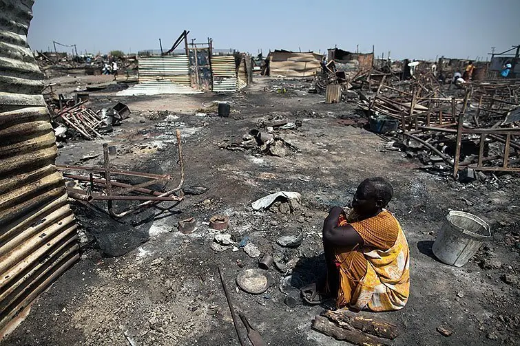 26 february 2016. Malakal : Akki Adduok, a displaced woman residing in the Protection of Civilians (PoC) site in Malakal, South Sudan, sits in the spot where there used to be her shelter.
Fighting between elements of the Shilluk and Dinka communities erupted in the Malakal PoC on February 17 and continued on February 18. UN reports confirm that armed men in Sudan People's Liberation Army (SPLA) uniforms entered the UN camp and fired on civilians, looting and burning tents. At least 18 people were killed and more than 90 wounded.
After the clashes, Dinka families (approximately 4,000 people) fled outside the PoC and sought refugee into Malakal town, while about 26,000 Nuer and Shilluk IDPs, mostly women and children, sought refugee in the former PoC.
Photo by Albert Gonzalez Farran / AFP