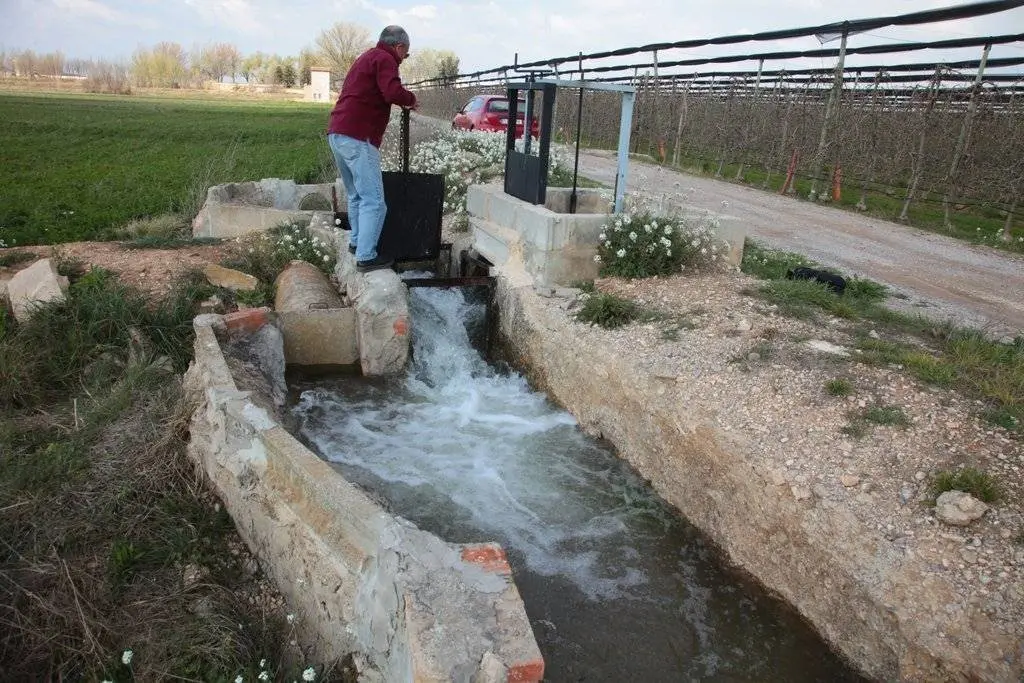 Un pagès alça la pala en una boquera de la finca ©JosepAPérez