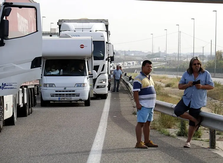 Persones a l'A-2 fora del vehicle i la cua de cotxes i camions pel tall de l'A-2 a Soses