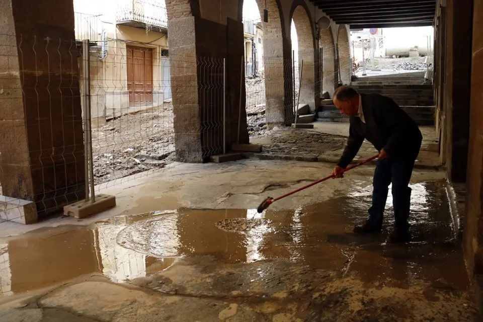 Un veí traient aigua del davant de casa al carrer Botera de Balaguer