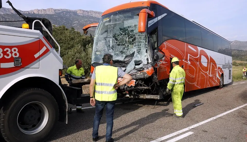 Pla obert on es pot veure l'autocar que ha impactat frontalment contra una furgoneta amb el resultat d'un mort a la C-12 a Àger mentre operaris i Bombers intenten retirar-lo de la via, el 21 de setembre de 2018. (Horitzontal)