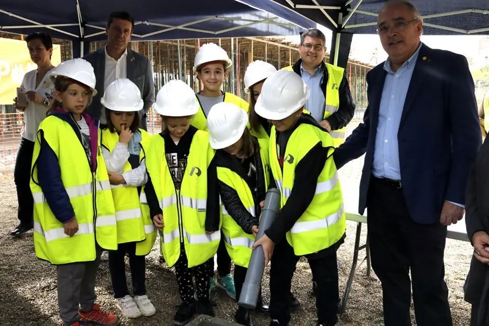 Imatge de l'alumnat de l'escola d'Almenar i el conseller Josep Bargalló enterrant un tub amb dibuixos i els diaris del dia com a mostra simbòlica del moment de la construcció del centre. El 19 d'octubre de 2018. (Horitzontal)