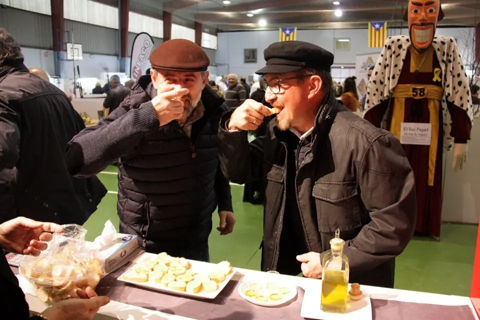 Pla mitjà de dues persones fent una degustació de pa amb oli en una de les parades de la 21a Fira de l'Oli Verd de Maials, el 18 de novembre de 2018 (Horitzontal).