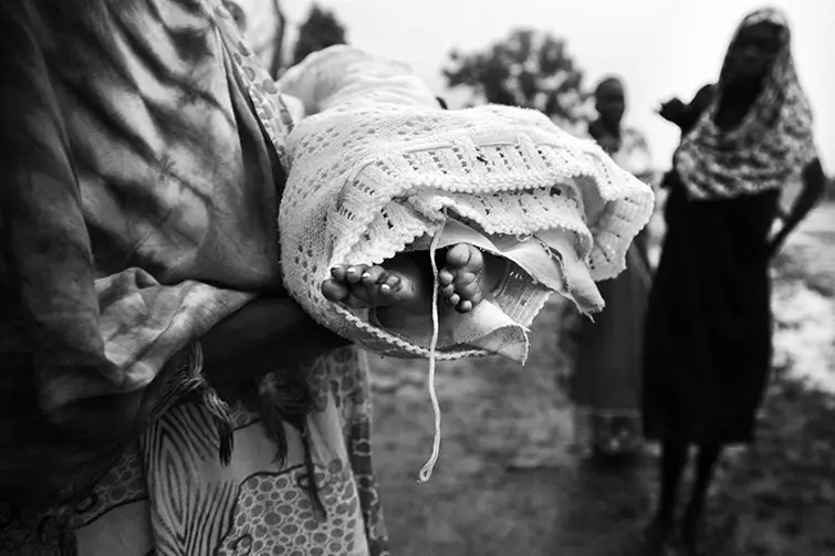 A relative holds the dead body of (right) Nyamuoch Kuoch&#39;s baby