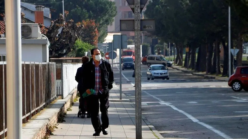 Una persona amb màscara passant per Mollerussa