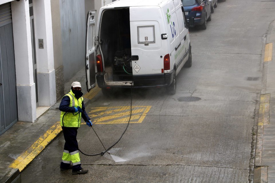 Pla mitjà on es poden veure serveis de neteja desinfectant un carrer de Mollerussa per tal de prevenir la propagació del coronavirus, el 18 de març de 2020. (Horitzontal)