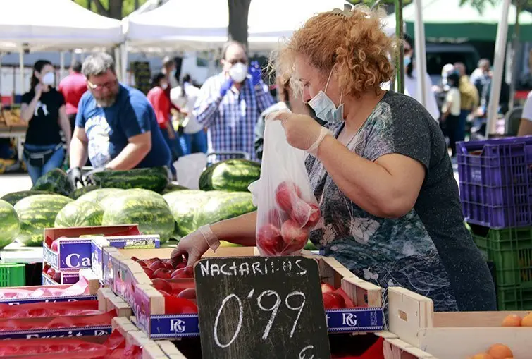 Una paradista equipada amb mascareta i guants al mercat del Barris Nord de Lleida