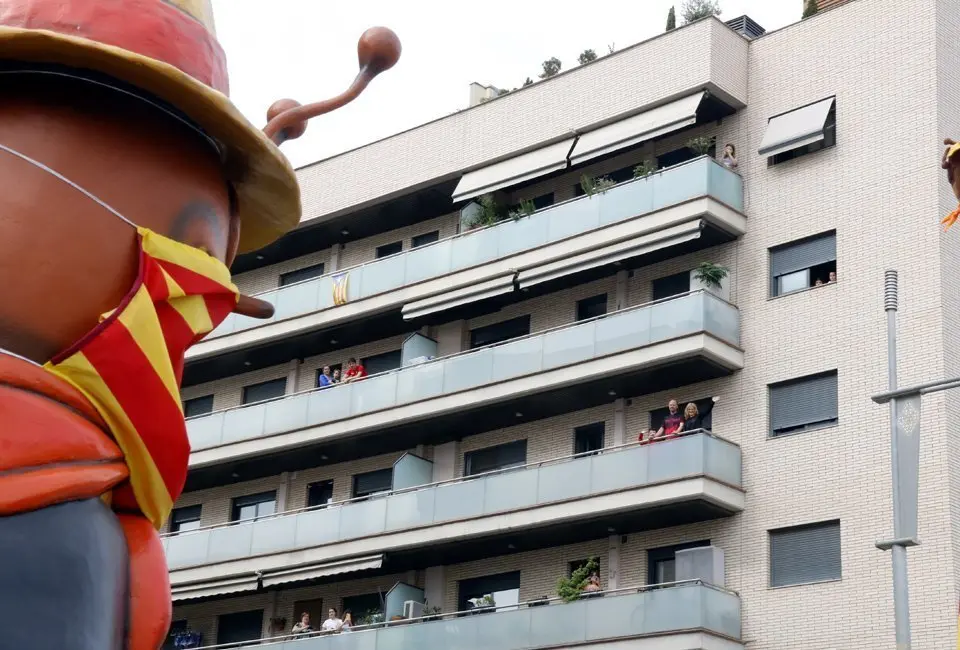 Pla obert de diversos veïns d'un bloc de pisos de Lleida mentre saluden la cercavila de l'Aplec del Caragol, el 24 de maig de 2020. (Horitzontal)