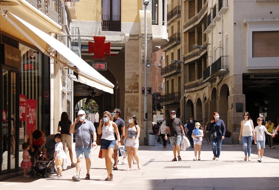 Pla general de diverses persones passejant amb mascareta per l'Eix Comercial de Lleida, a l'alçada de la plaça de la Paeria en el primer diumenge de rebaixes que coincideix amb el confinament perimetral del Segrià, el 5 de juliol de 2020 (Horitzotal).