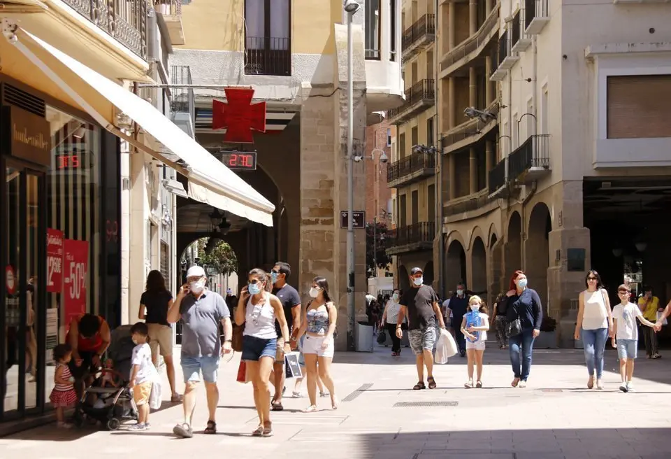 Pla general de diverses persones passejant amb mascareta per l'Eix Comercial de Lleida, a l'alçada de la plaça de la Paeria en el primer diumenge de rebaixes que coincideix amb el confinament perimetral del Segrià, el 5 de juliol de 2020 (Horitzotal).