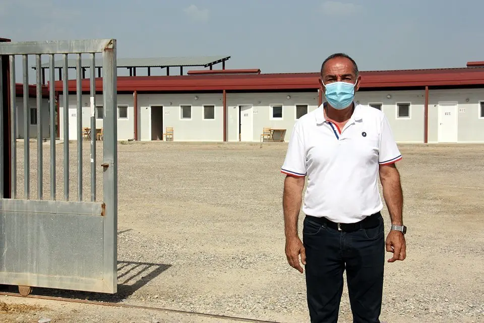 Pla mitjà de l'alcalde d'Alcarràs, Manel Ezquerra, a l'exterior de l'alberg municipal que ha habilitat l'Ajuntament per acollir treballadors de la campanya de la fruita amb símptomes de covid-19, el 9 de juliol de 2020. (Horitzontal)