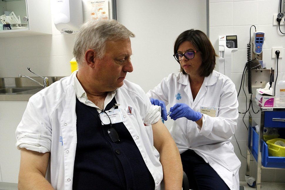 Pla mitjà on es pot veure un auxiliar d'infermeria del CAP Onze de Setembre de Lleida vacunant-se per la grip, el 28 d'octubre de 2019. (Horitzontal)
