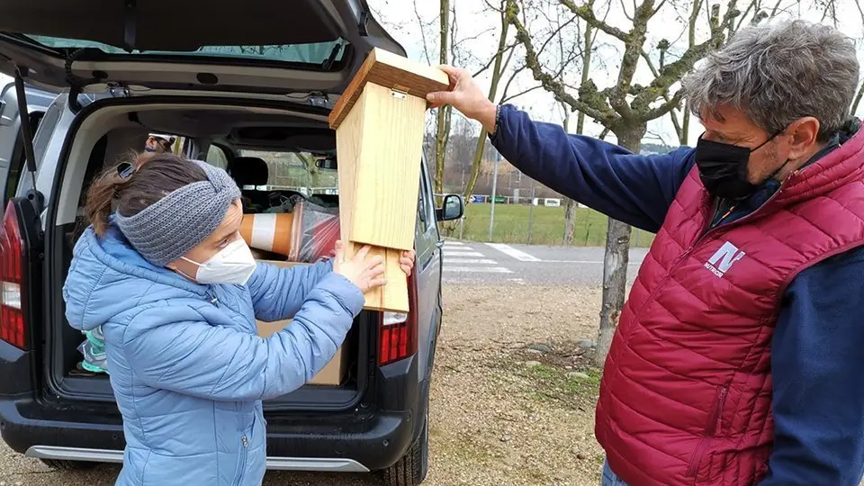 Dos dels voluntaris amb una de les caixes instal·lades