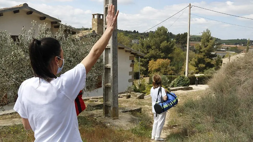 Pla mitjà on es poden veure dues infermeres en el moment d'arribada a una masia d'Ivorra per vacunar contra la covid-19 a una senyora de 87 anys, el 8 d'abril de 2021. (Horitzontal)