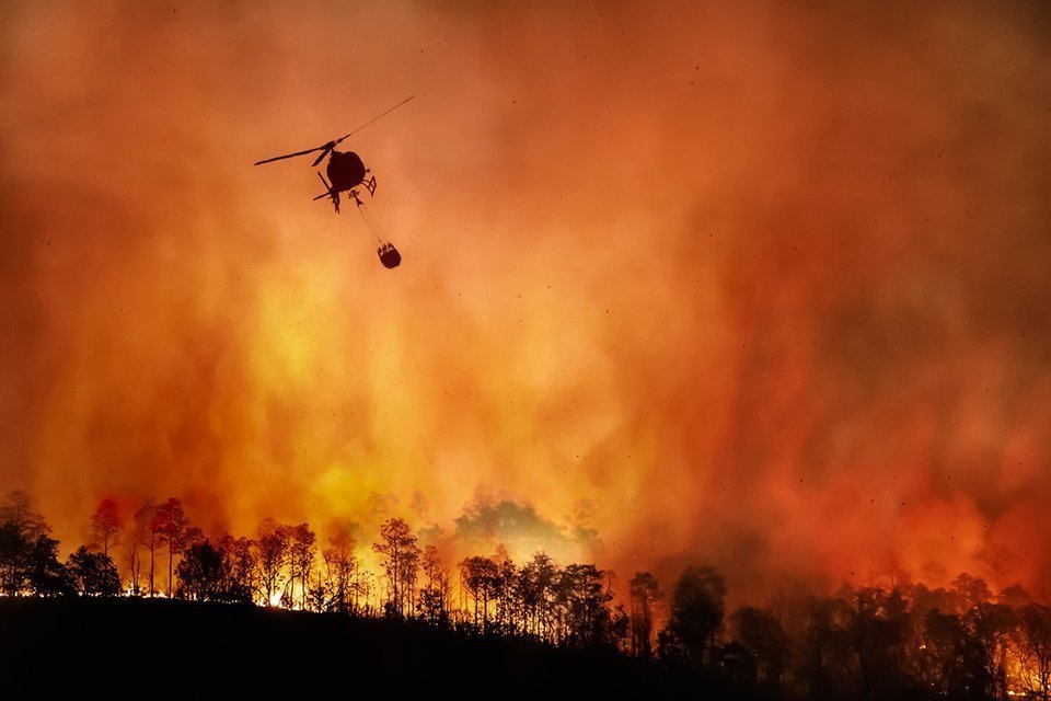 Un helicòpter contra incendis transporta una aigua per extingir l’incendi forestal @Arxiu