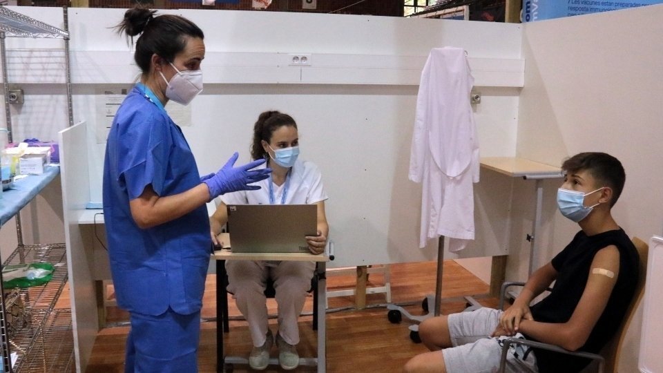 Una infermera donant explicacions a un jove que acaba de rebre la vacuna contra la COVID-19 a Lleida.