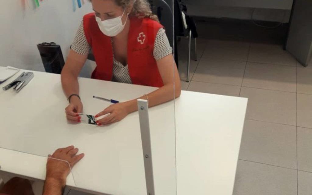 Cedida per la Creu Roja Lleida
Pla mitjà on es pot veure una voluntària de la Creu Roja Lleida repartint targetes aliment. (Vertical)