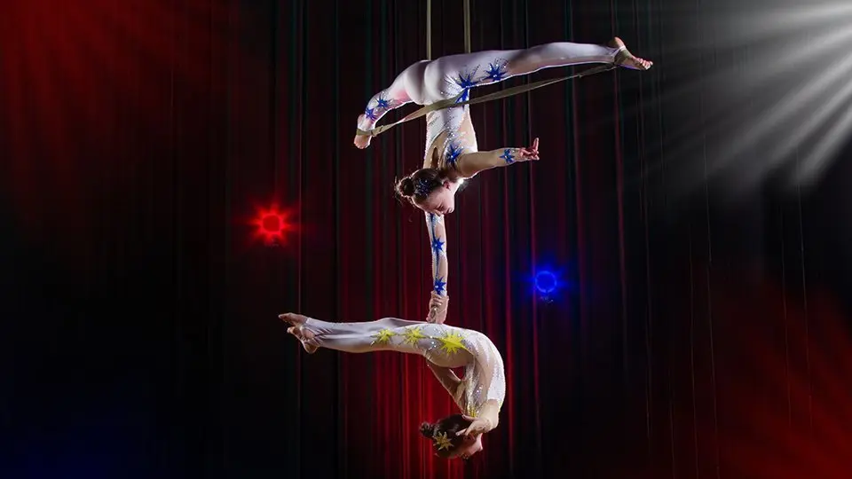 Circus actress acrobat performance. Two girls perform acrobatic elements in the air.