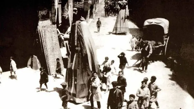 Els gegants del barri de la Mercè de Tàrrega, acompanyats per la banda municipal de música, anuncien l'inici de la Festa Major ©Pascual Gumersindo. 1920. Arxiu AFMCUT. Col·lecció Albert Fitó