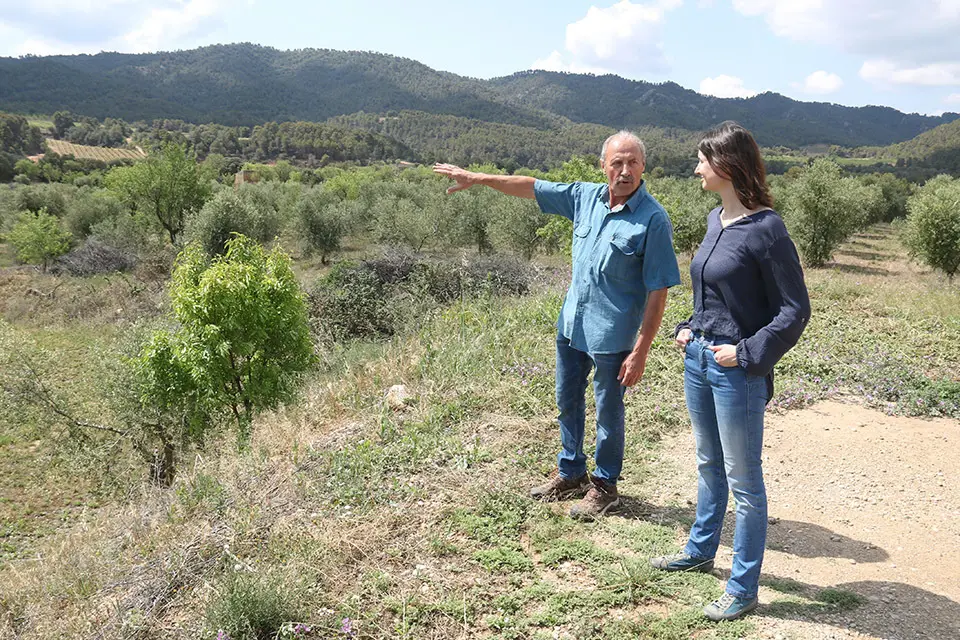 Sara Jové, secretària de l'associació, i Zacaries Sobrepere, tresorer, conversen sobre la Serra de la Llena. Localització: La Pobla de Cérvoles, 3 de juny 2023 - Foto: Ignasi Gómez (ACN)