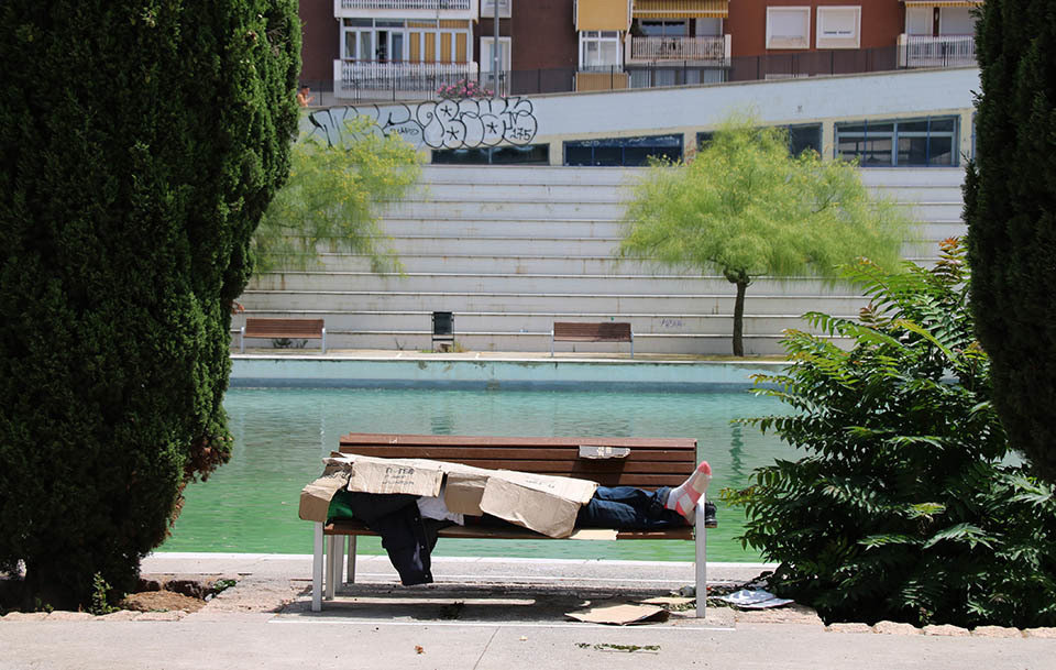 Una persona sense sostre protegint-se de la calor amb cartrons - Foto: Norma Vidal