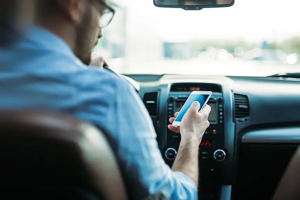 transportation concept - man using phone while driving the car