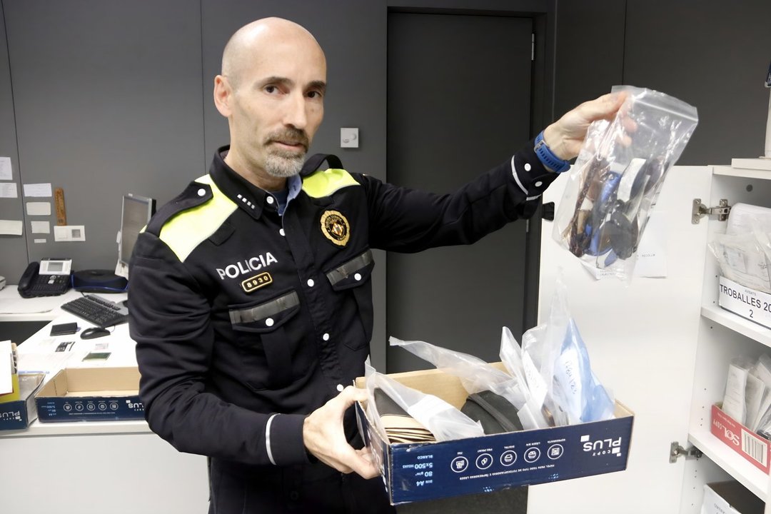 L'agent Josep Borges mostrant una caixa d'objectes perduts a la comissaria de la Guàrdia Urbana de Lleida - Foto: Oriol Bosch