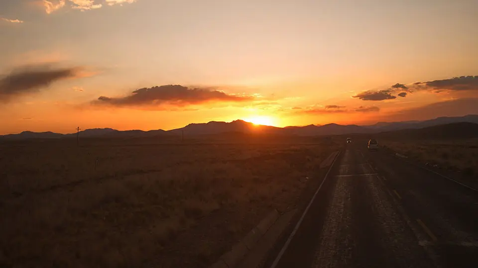 Sunset view through the bus window of a road through the highlands of Peru