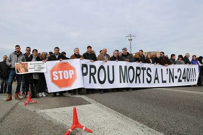 Manifestants darrere d'un cartell reclamant 'Prou Morts', a la N-240 a Juneda. Imatge del 29 de gener de 2017. (Horitzontal)