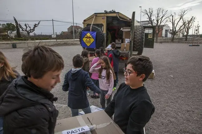 Alumnes de l'escola Mare de Déu de l'Horta carreguen els aliments