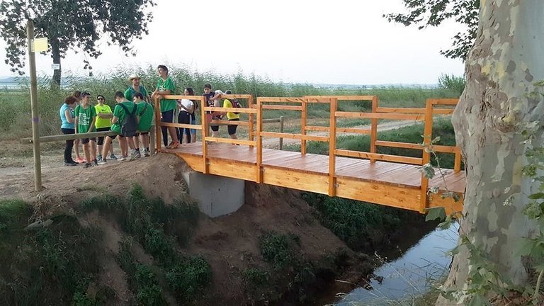 Els voluntaris del Camp de Treball sobre la passarel·la a Linyola int
