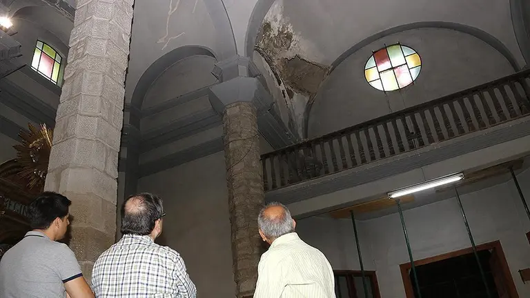 Tècnics observant la part esfondrada del fals sostre de l'església del Palau d'Anglesola
