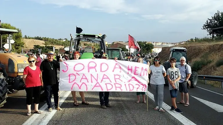 Un grup de persones afectades pel foc de la Ribera d'Ebre durant un tall de la C-12