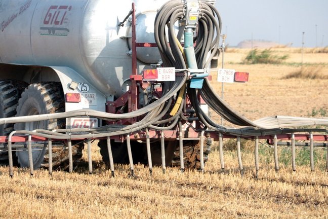 Pla detall d'un tractor amb una cisterna aplicant purins en una finca d'Albesa mitjançant el sistema de tubs penjants, el 3 de juliol del 2019. (Horitzontal)