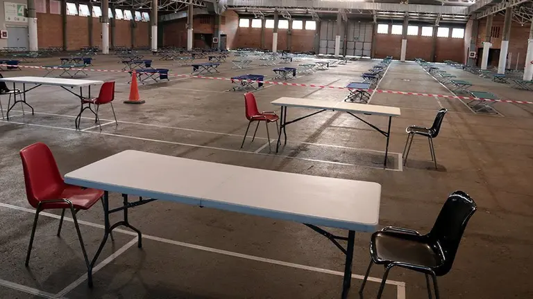 Imatge de les taules del menjador i dels llits al fons instal·lats al pavelló 3 de Fira de Lleida, l'1 de juny del 2020. (Horitzontal)