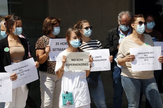 Treballadors sanitaris concentrats davant l&#39;Hospital Universitari Arnau de Vilanova de Lleida amb cartells per reclamar els seus drets. Imatge del 9 de juny de 2020. (Horitzontal)