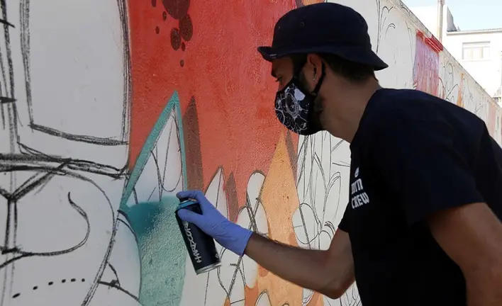 L'artista Zach Oreo pintant l'obra del GarGar de Penelles