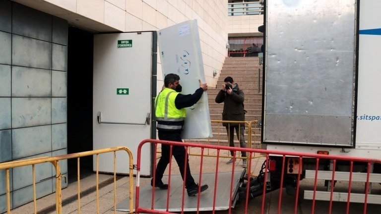 Operaris de l'empresa de transport carregant al Museu de Lleida una de les peces d'art de la Franja dins del camió, el 22 de febrer del 2021. (Horitzontal) - Salvador Miret