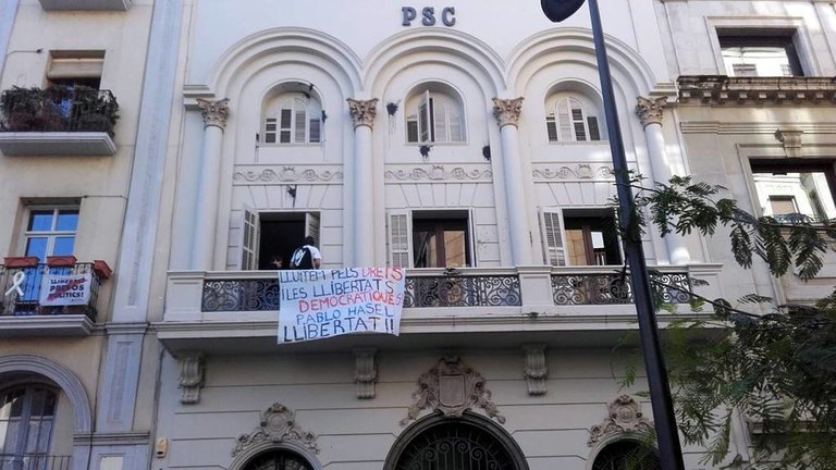 Pla obert on es pot veure la pancarta demanant la llibertat de Pablo Hasel penjada al balcó de la seu del PSC de Lleida, el 22 d'octubre de 2018.

Data de publicació: dilluns 22 d’octubre del 2018, 12:52

Localització: Lleida

Autor: Cedida per Llibertat Pablo Hasél