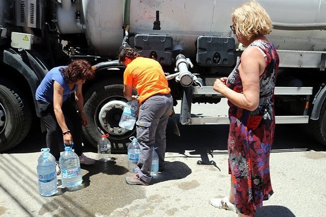 Els veïns de Sarroca de Lleida omplen garrafes d'aigua en una cisterna ©SalvadorMiret