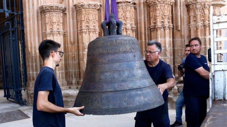 Dos operaris descarregant la campana Mònica, una vegada ha estat restaurada, a la Seu Vella de Lleida ©Oriol Bosch